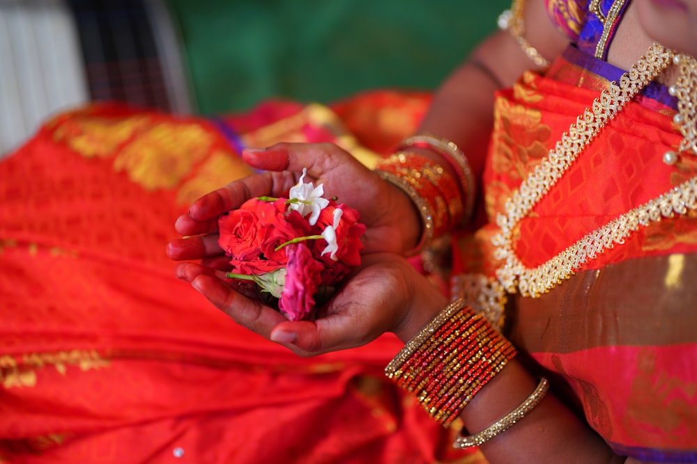 person holding red and white flower