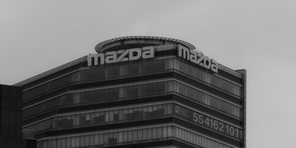 a black and white photo of a building with a sign on top