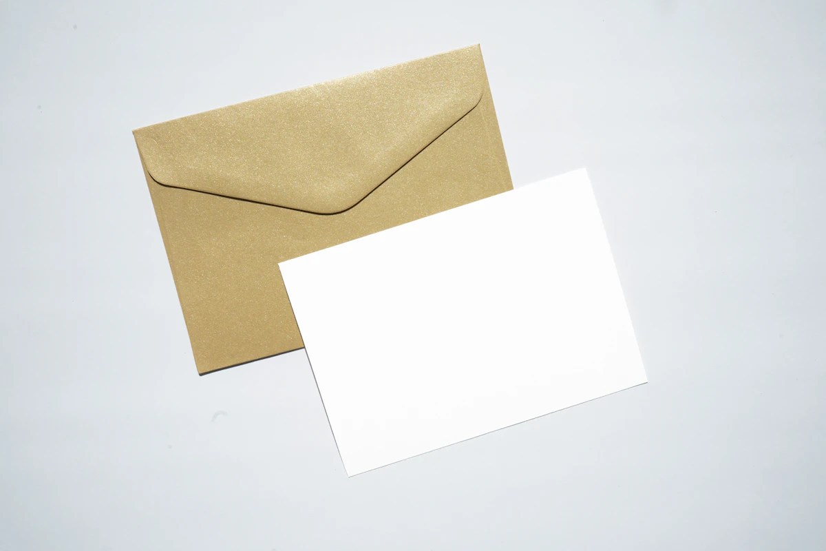 Hojas de papel membretado en blanco sobre un sobre kraft, composición flat lay