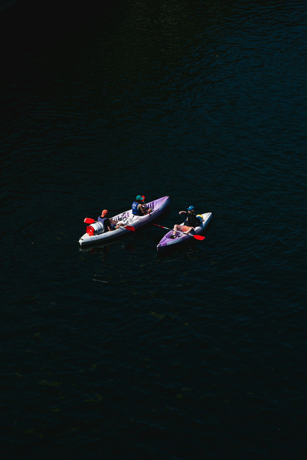 2 people riding on white and red kayak on body of water during daytime