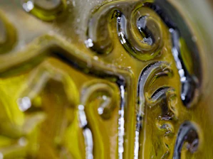 Close-up of shimmering, translucent emerald glass with fluid light refractions.