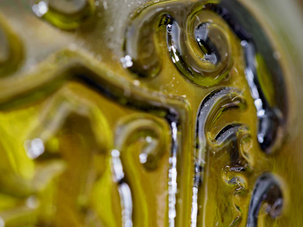 Close-up of shimmering, translucent emerald glass with fluid light refractions.