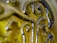 Close-up detail of a green glass surface with decorative swirls and embossed patterns, reflecting light and creating a glossy texture.