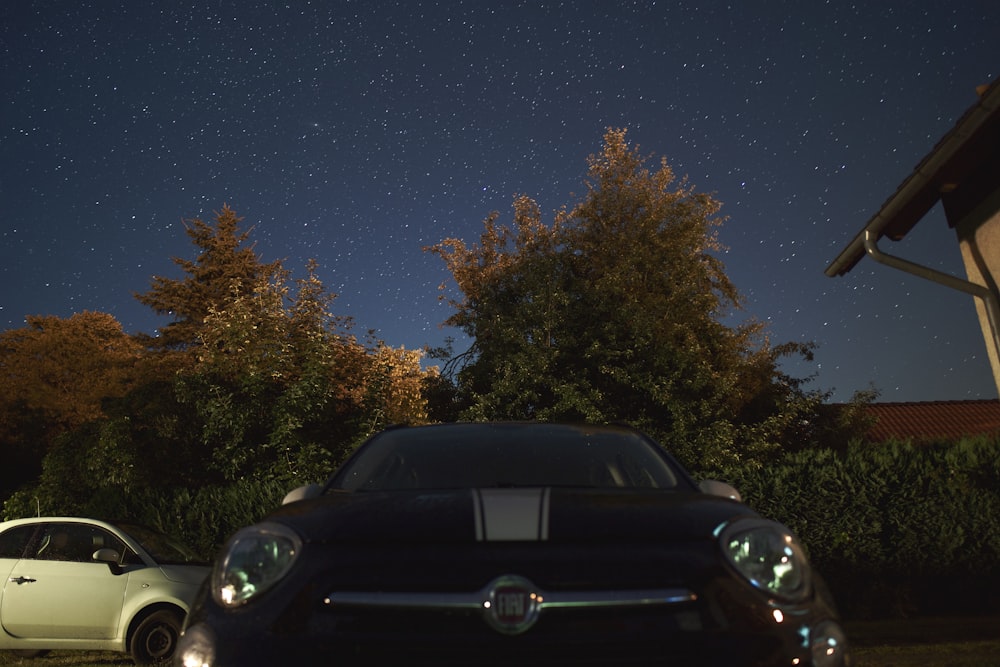 black car parked near green trees during night time