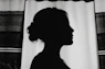 silhouette of woman standing near window