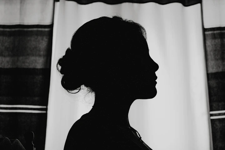 Silhouette of a woman by a window
