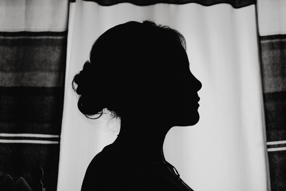 silhouette of woman standing near window