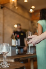 A close-up of wine glasses filled with red wine, set on a rustic wooden table.