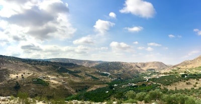 A panoramic view of a mountain valley with patches of cultivated land.