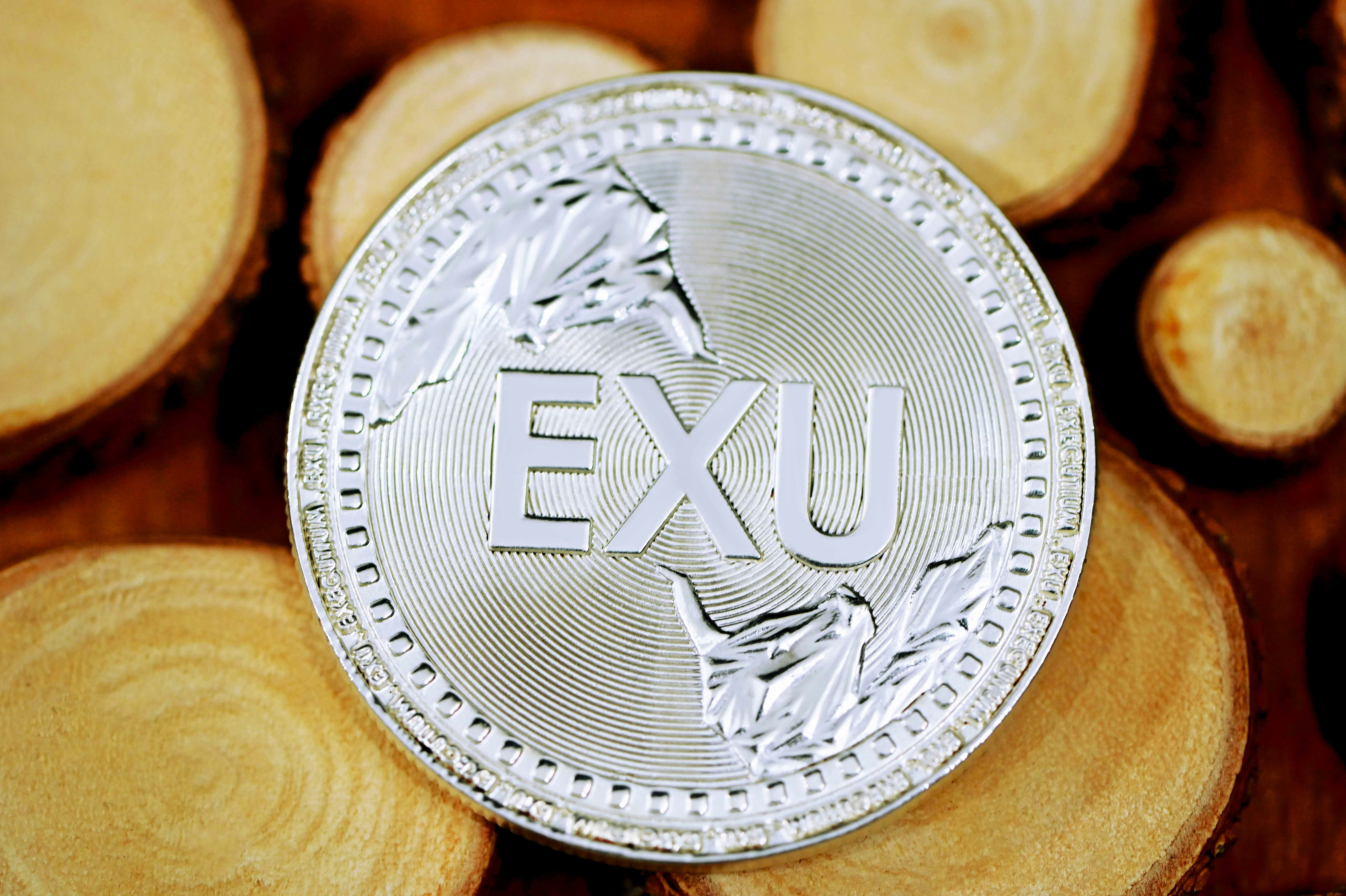 silver round coin on brown textile