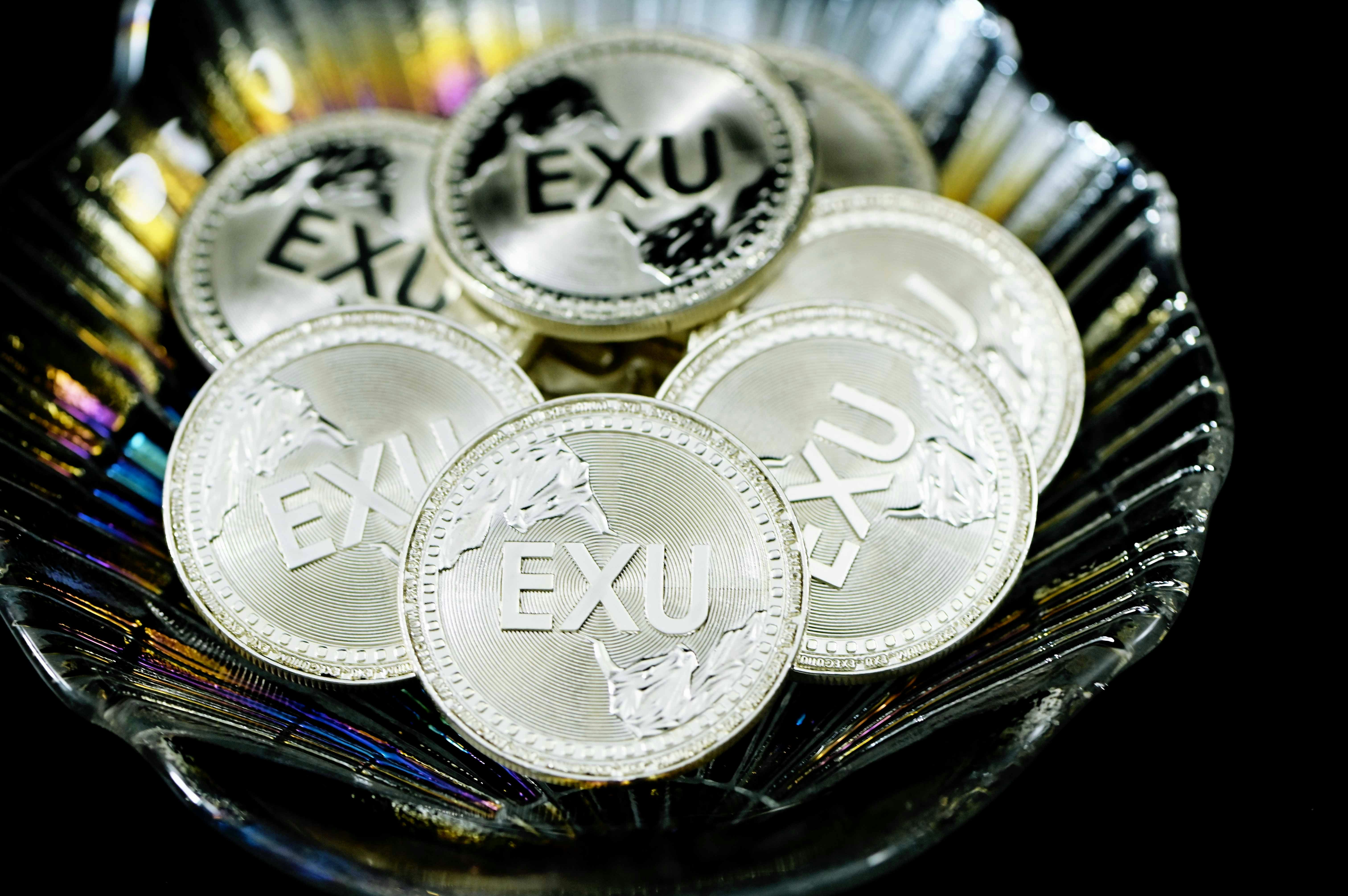 A pile of EXU silver coins on a seashell plate