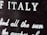 Close-up view of a textured surface with white text partially blurred. The letters are prominently visible, with 'ITALY' clearly noticeable.