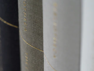 Close-up of a handcrafted art catalog with earthy red and black tones