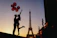 Elegant couple enjoying a sunset view from a luxury hotel balcony in Paris.