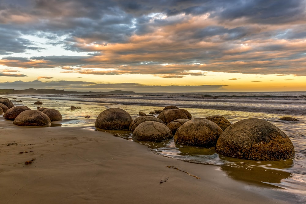 brown rocks on body of water during sunset