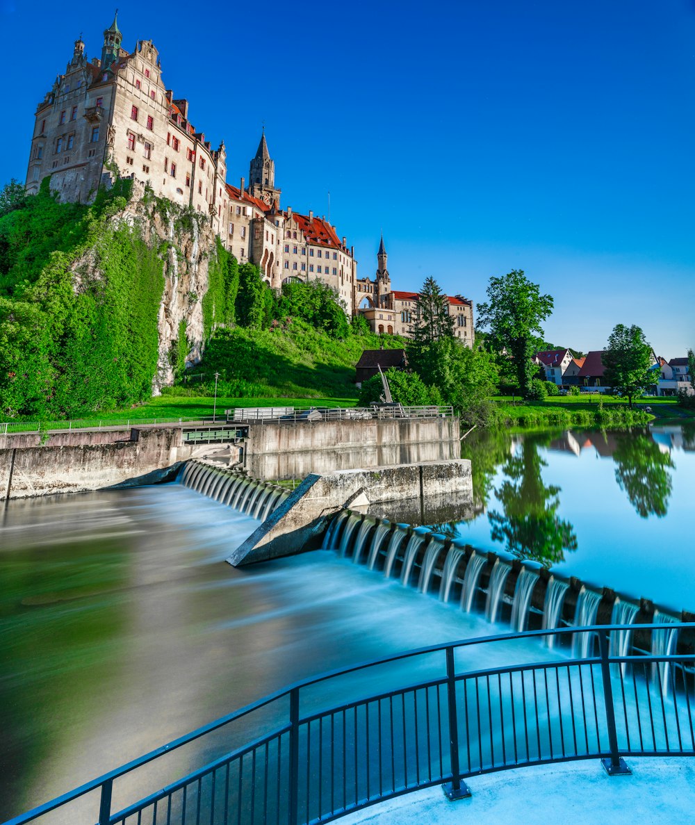 brown concrete building near river under blue sky during daytime