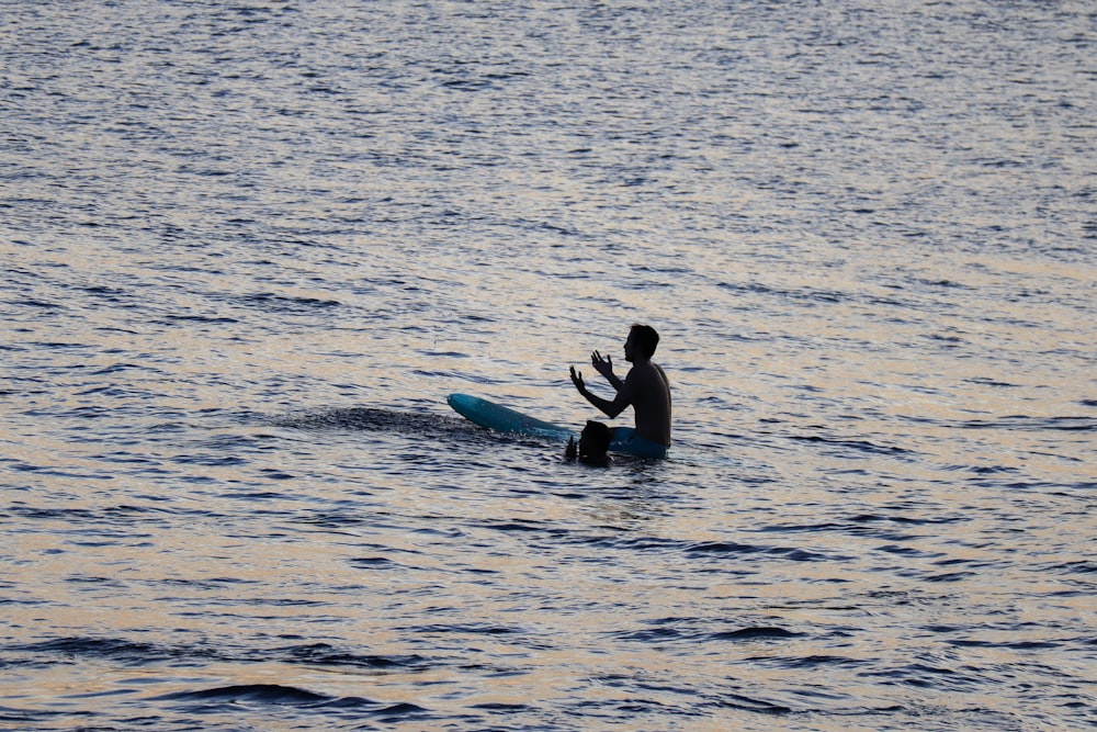 woman in black swimsuit holding green surfboard on water during daytime