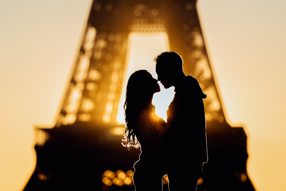 silhouette of man and woman kissing during sunset