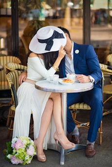A passionate couple sharing a secret moment in a cozy Parisian café, with vibrant red accents around them.