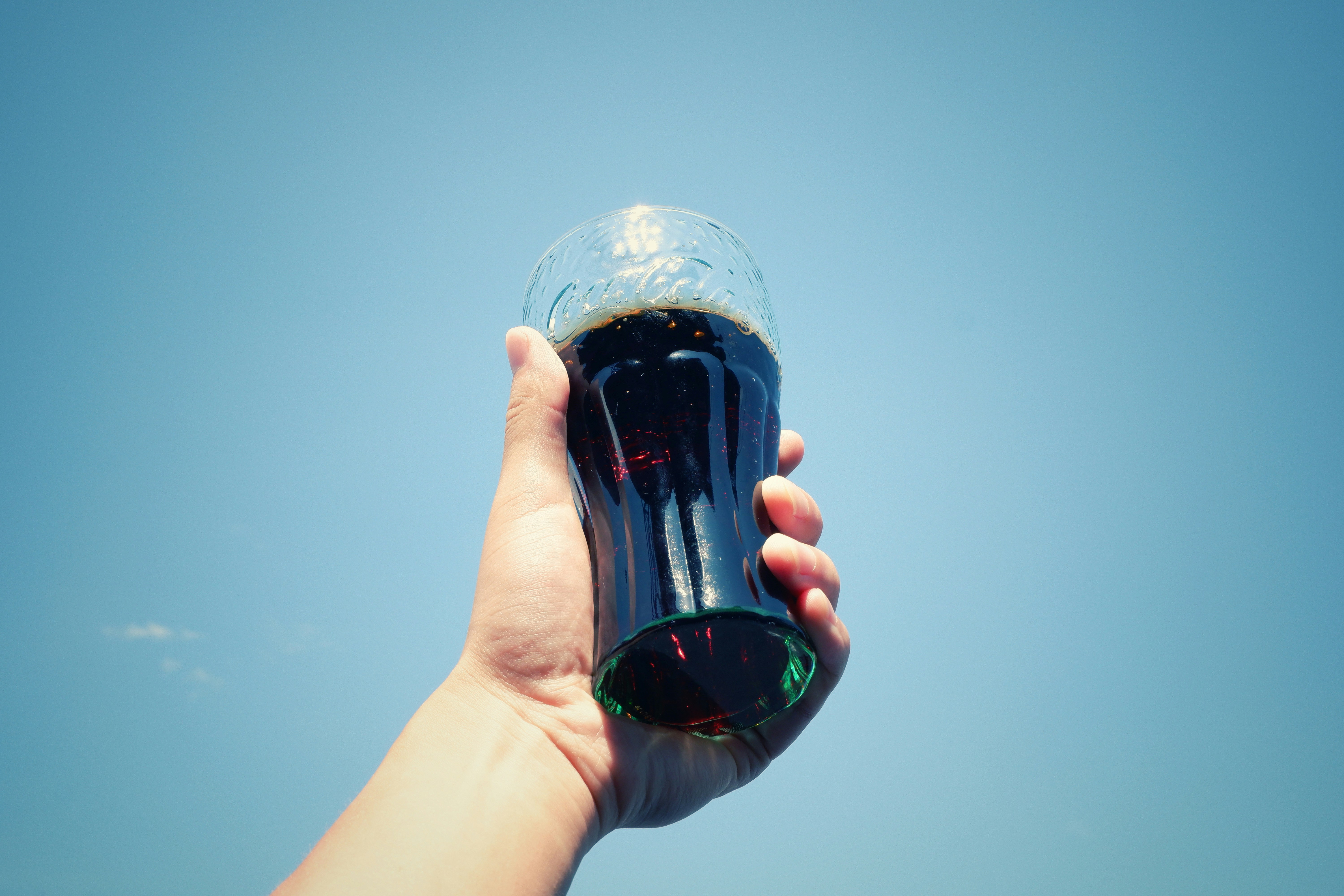 person holding coca cola bottle