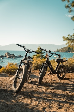 black and gray bicycle on brown sand near body of water during daytime