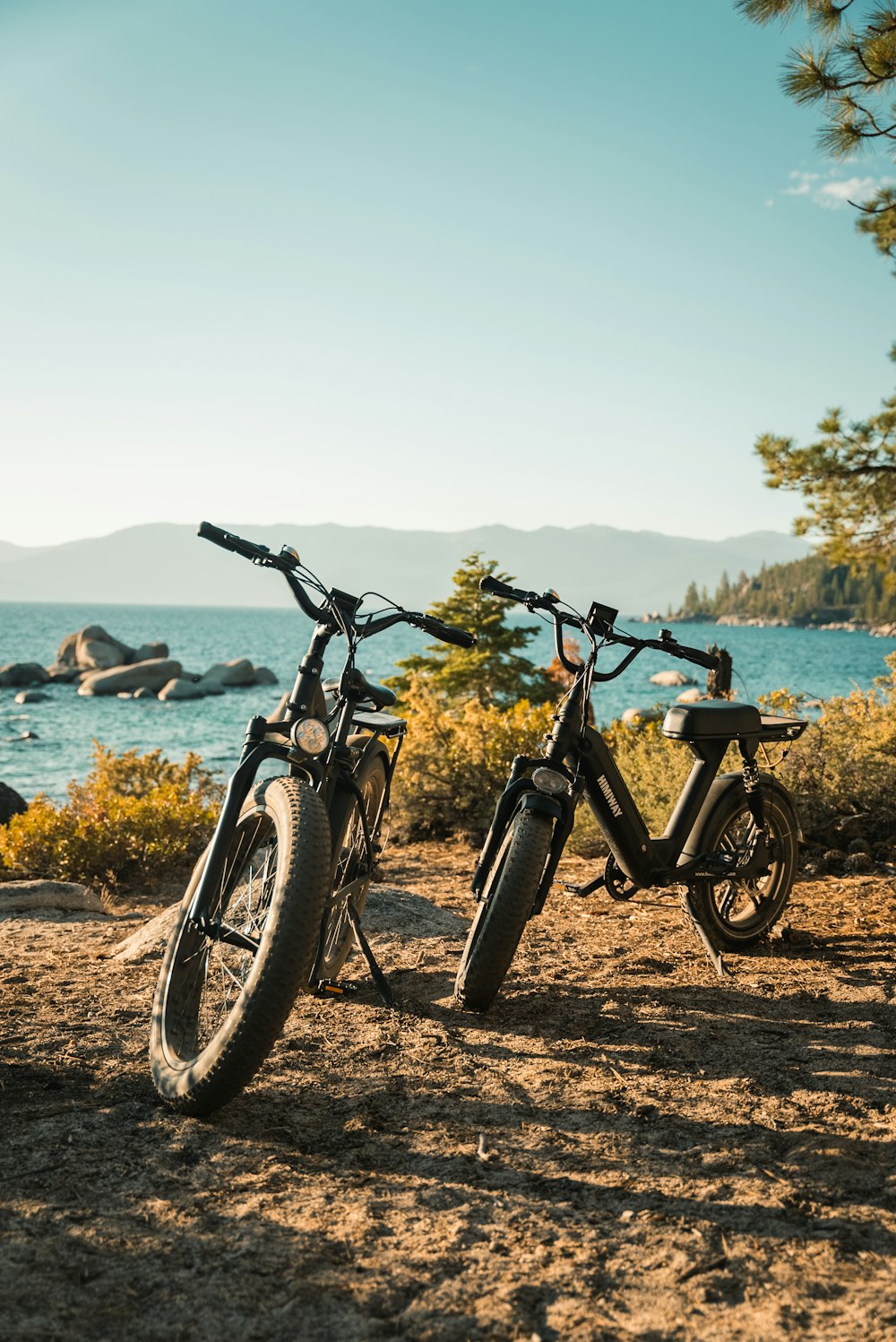 Schwarz-graues Fahrrad auf braunem Sand in der Nähe von Gewässern tagsüber