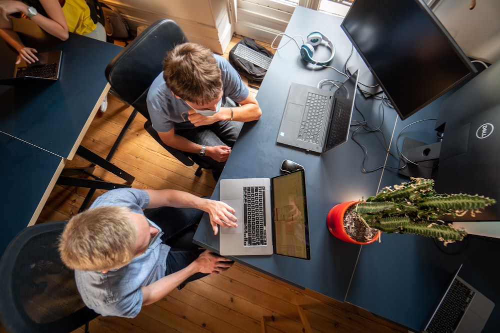 Hombre con camisa gris de manga larga usando MacBook Pro