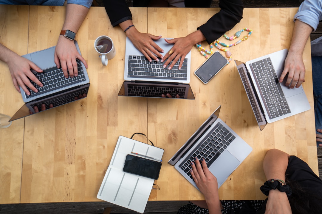 An overhead view of a marketing team sitting with their laptops at a table discussing the benefits of Search Focus for SEO