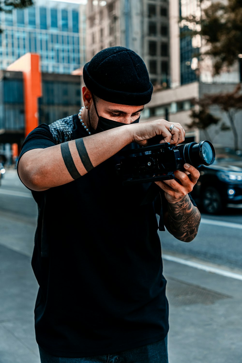 man in black jacket holding black dslr camera