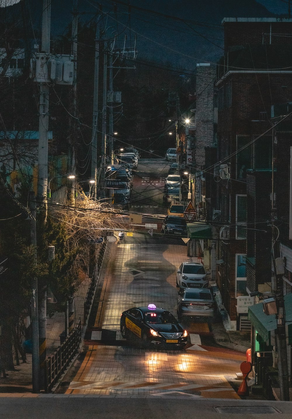 cars on road near buildings during night time