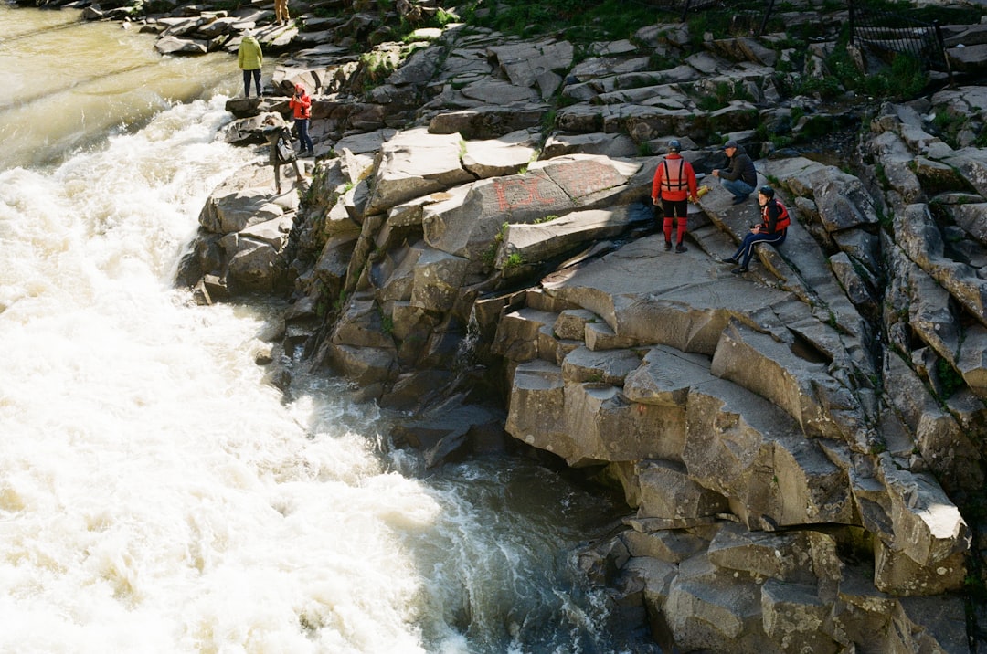 people on rocky river during daytime