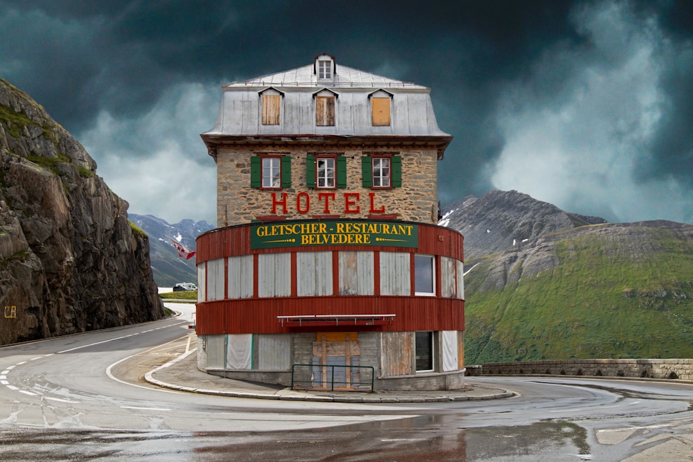 red and brown concrete building near mountain under white clouds during daytime