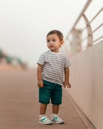 boy in white and gray stripe crew neck t-shirt and blue denim shorts standing on on on on on