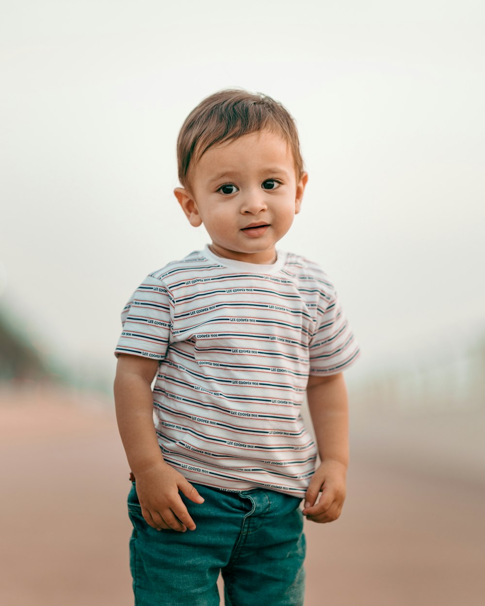 boy in white and gray striped shirt and blue denim shorts