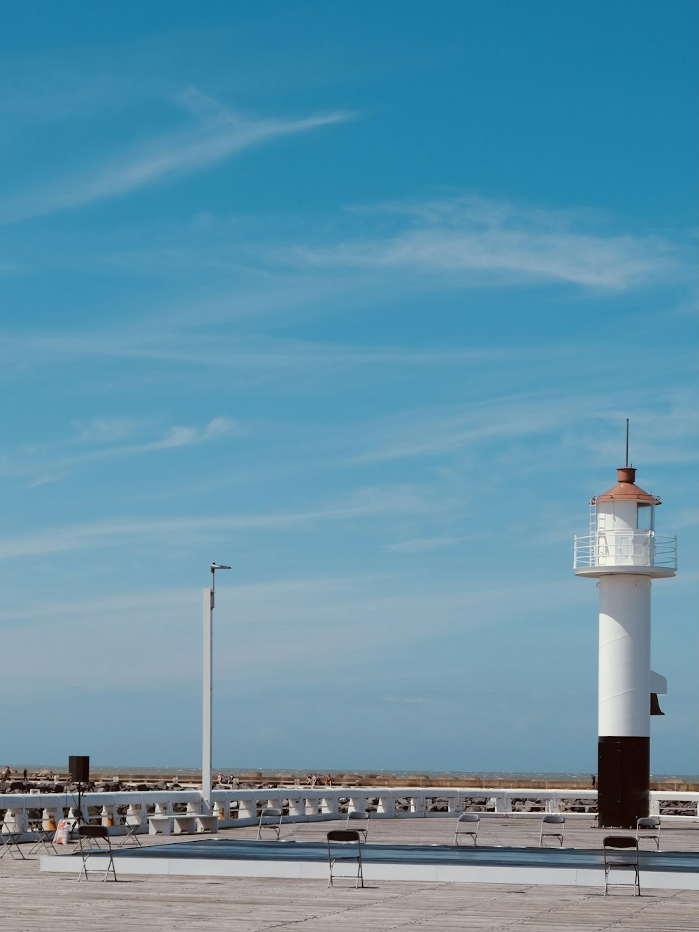 Faro blanco y negro bajo el cielo azul durante el día