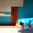 A rustic wooden bench stool placed by a bright, welcoming front door.