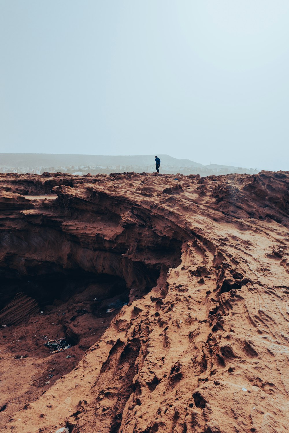 person standing on brown rock formation during daytime