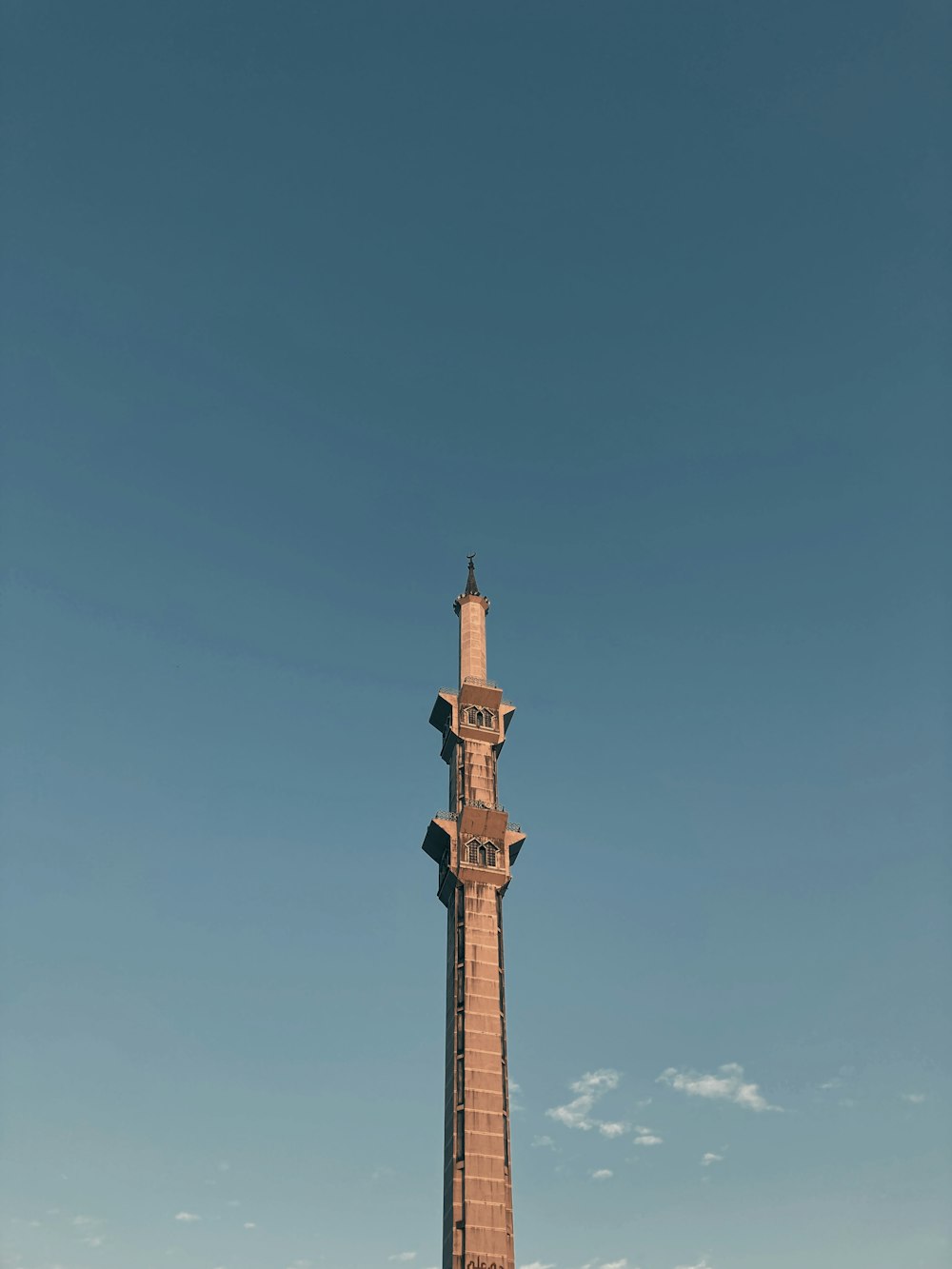 torre di cemento marrone sotto il cielo blu durante il giorno