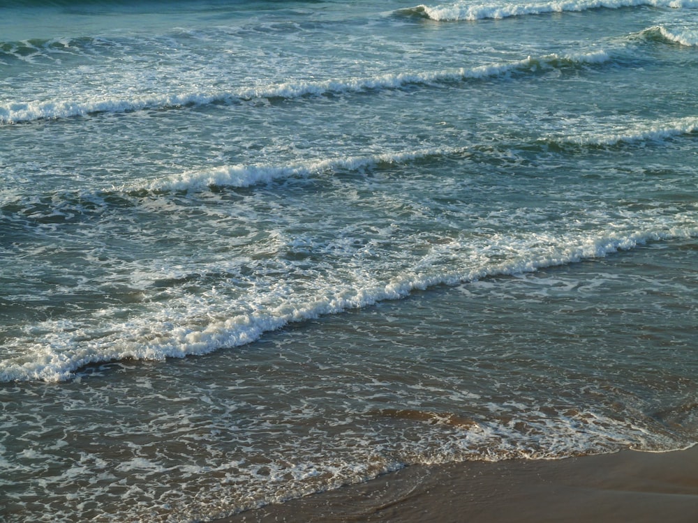 ocean waves crashing on shore during daytime