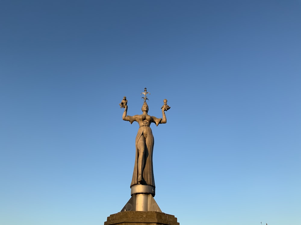 gold statue of man raising his hands