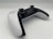 A modern video game controller with a sleek design featuring a combination of black and white colors. Two analog sticks, a directional pad, and various buttons are visible, positioned on a clean, minimalistic surface. The controller is angled slightly, giving a dynamic perspective.