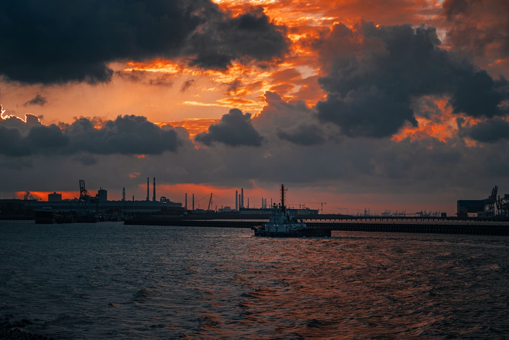 silhouette of ship on sea under cloudy sky during sunset