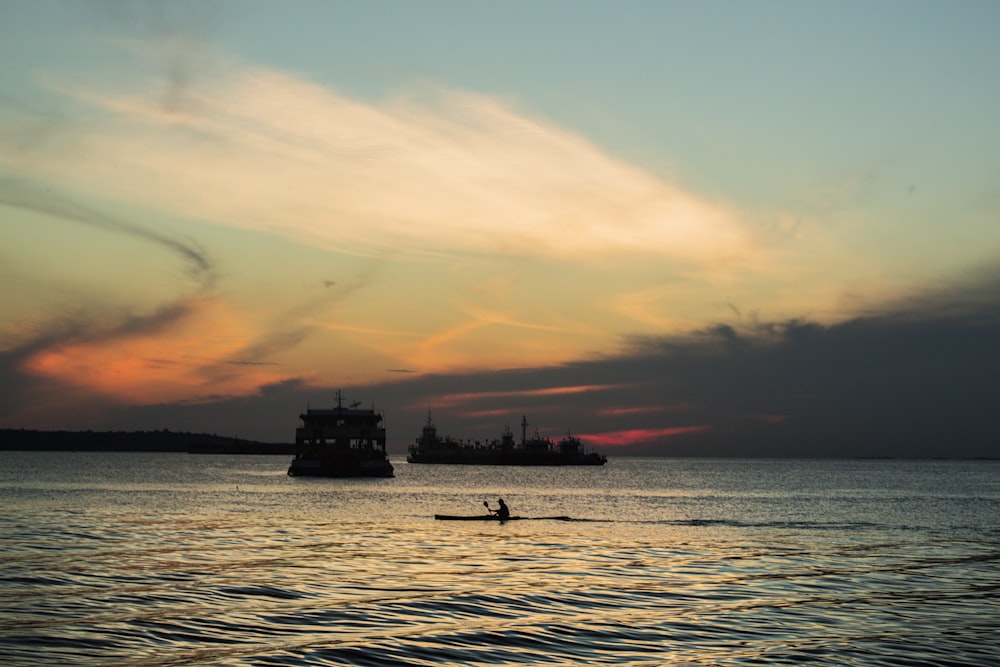 silhouette of boat on sea during sunset