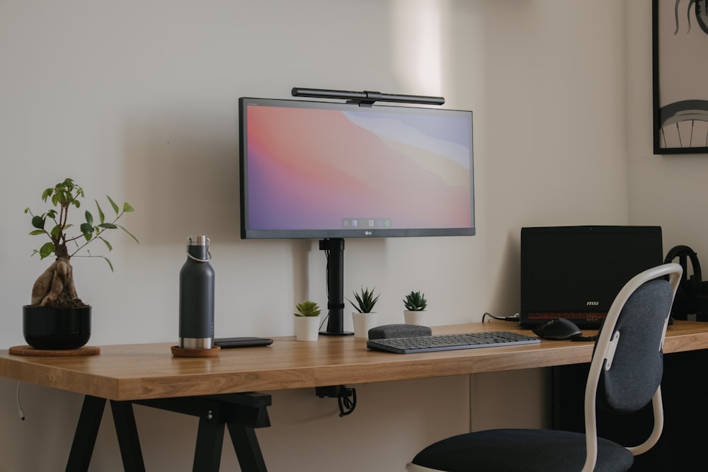 black flat screen tv turned on near black computer keyboard on brown wooden table