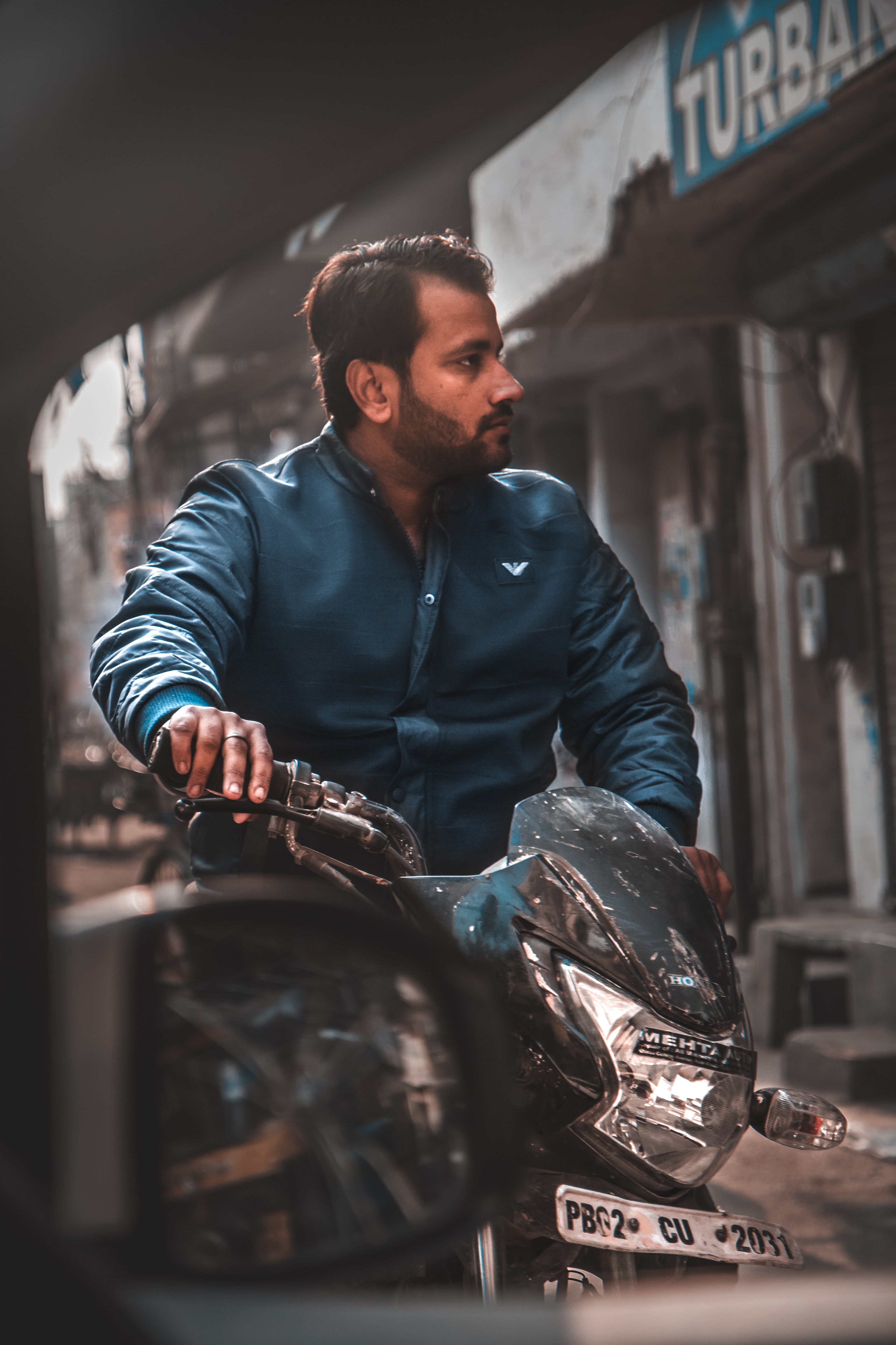 man in blue zip up jacket riding motorcycle