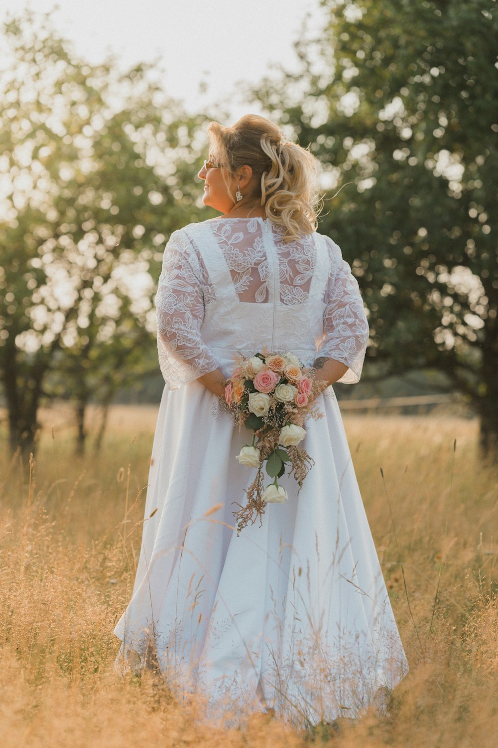 Frau in weißem langärmeligem Kleid mit Blumenstrauß