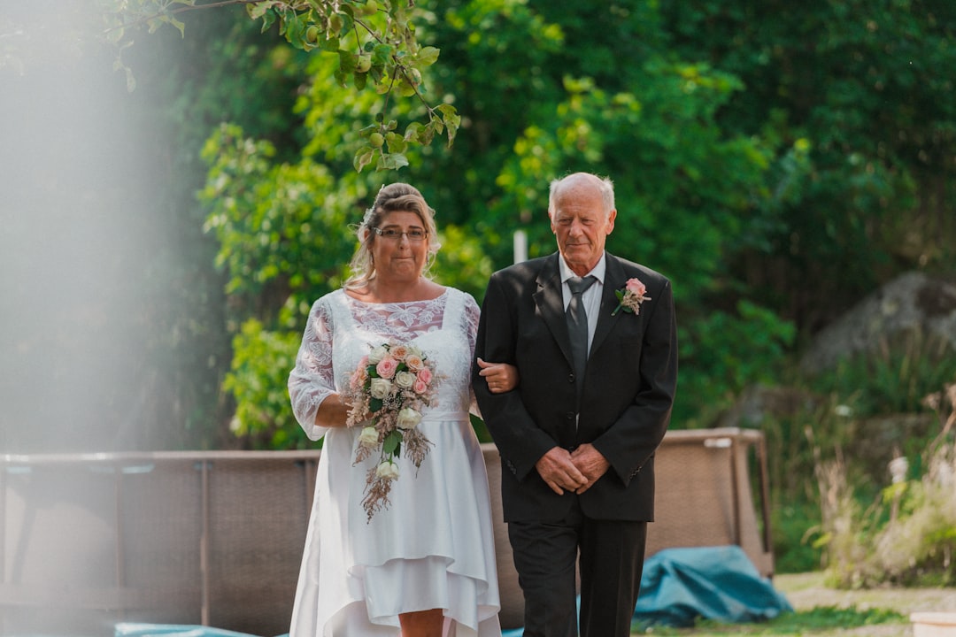 man in black suit standing beside woman in white wedding dress