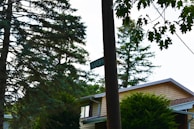 A custom wooden address sign mounted on a rustic post, blending seamlessly with a home's exterior.