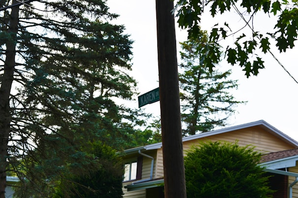 A freshly installed white postline sign post standing on a suburban lawn under a clear blue sky.