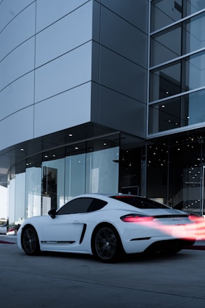 A sleek car parked in front of a modern building with a stopwatch overlay symbolizing speed.